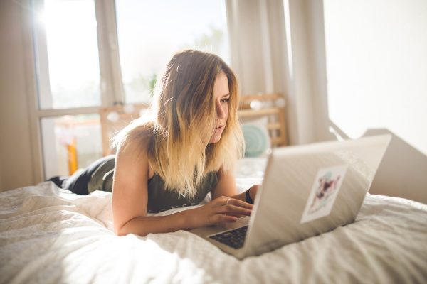 Girl on laptop in bedroom Photo by JiYÌ Wagner on Unsplash